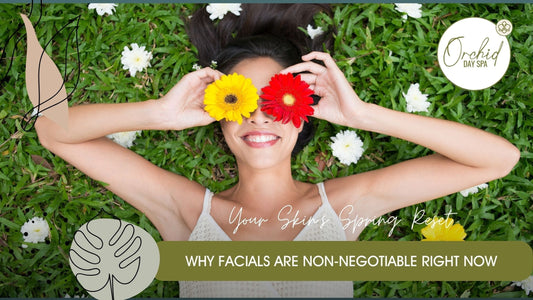 Smiling woman lying on fresh green grass holding bright flowers over her eyes, representing relaxation, renewal, and the rejuvenating benefits of spa treatment specials at Orchid Day Spa