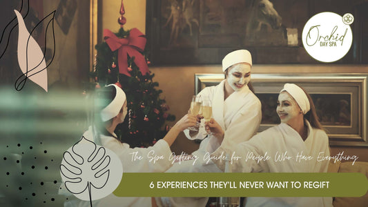 Three women in spa robes with facial masks clinking champagne glasses beside a Christmas tree – enjoying a festive spa day at Orchid Day Spa, a perfect setting for spa gift vouchers in South Africa.